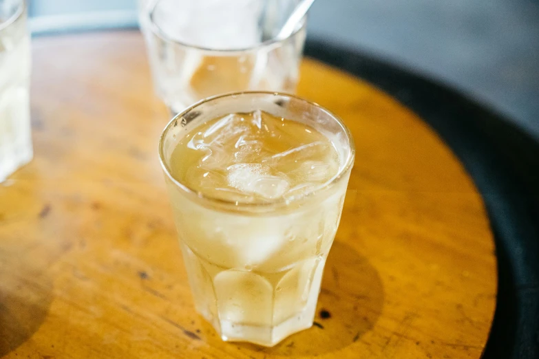 three glasses sitting on a table containing liquid