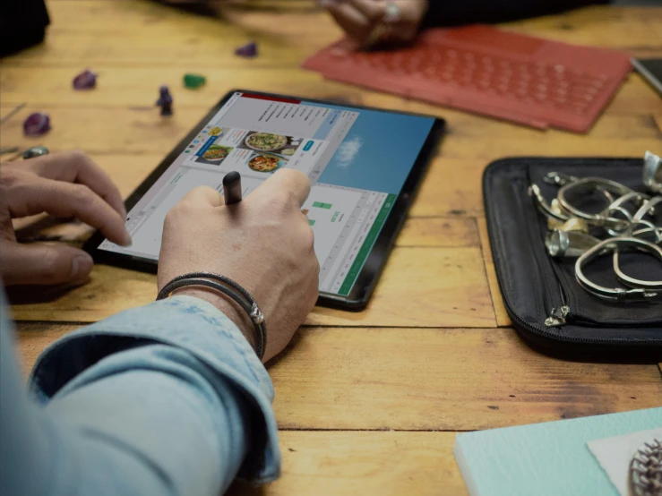 people sit at a table with a tablet computer