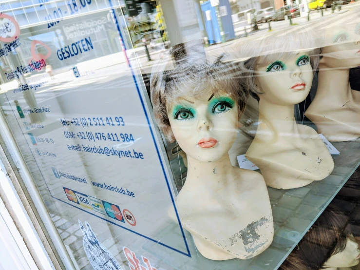 two women's heads sitting behind a window display