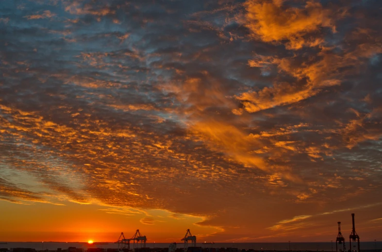 the sun is setting over a harbor at dusk