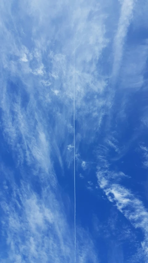 a very blue cloudy sky with some kites in it