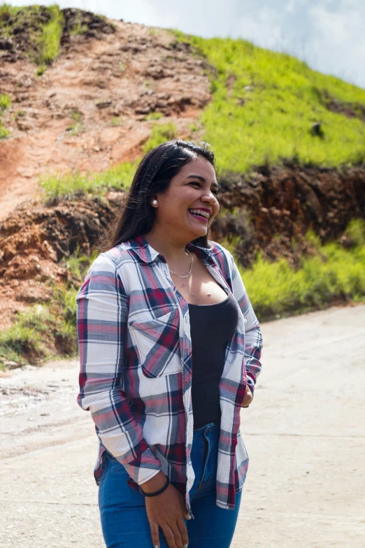 a woman on the street smiles and looks off to the side