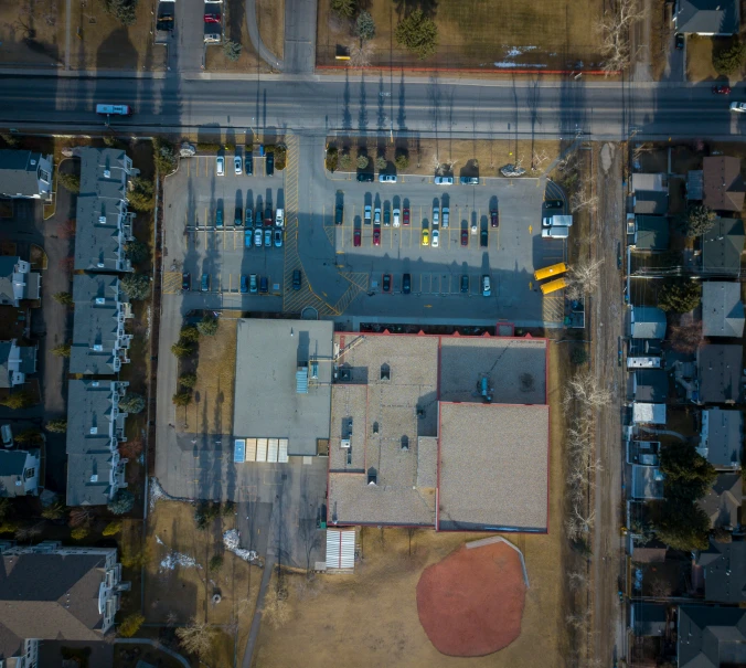 aerial view of two parking garages and parking lot with skateboarders in the background