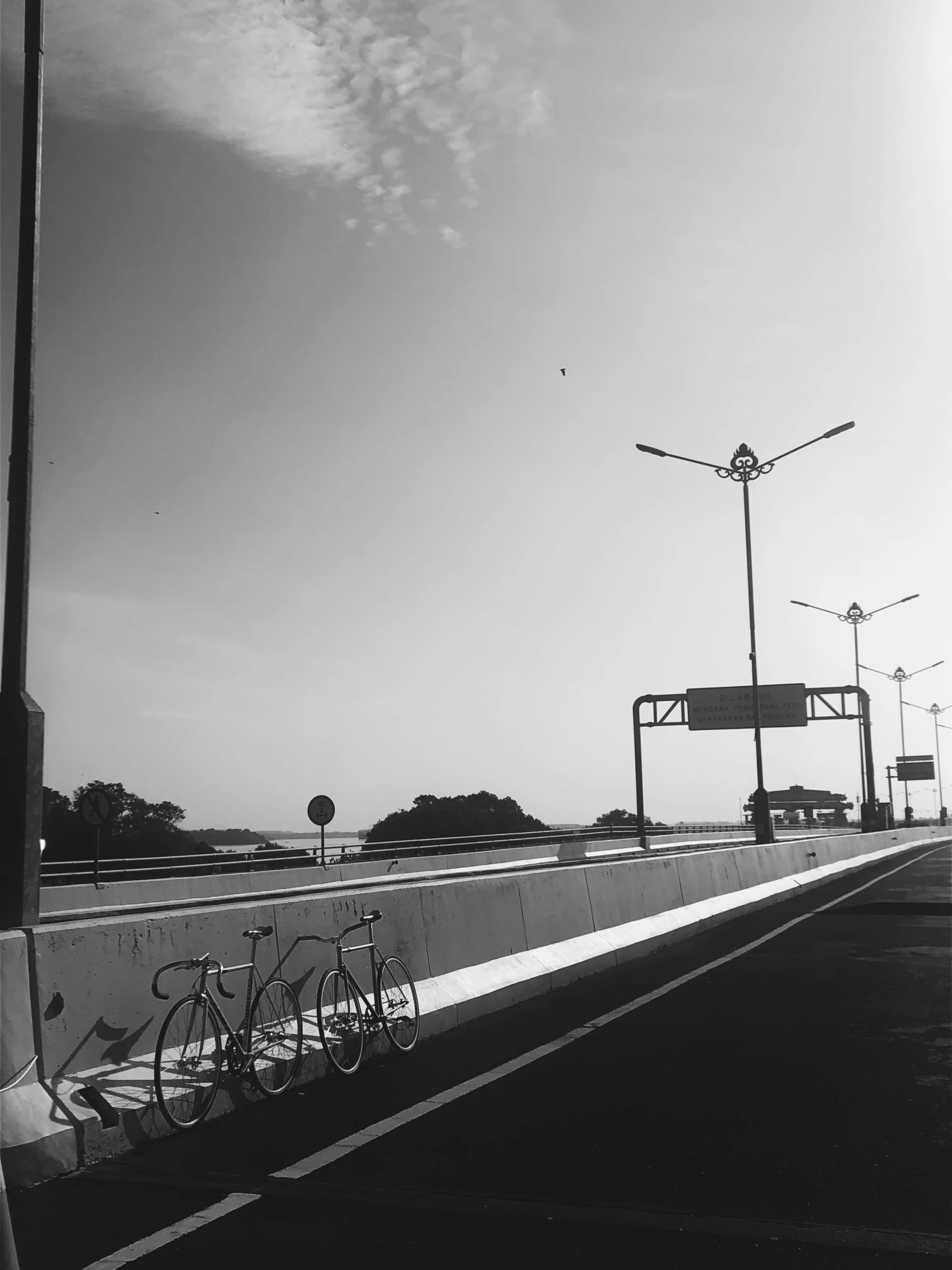 a bike leaning against the fence on the side of the road