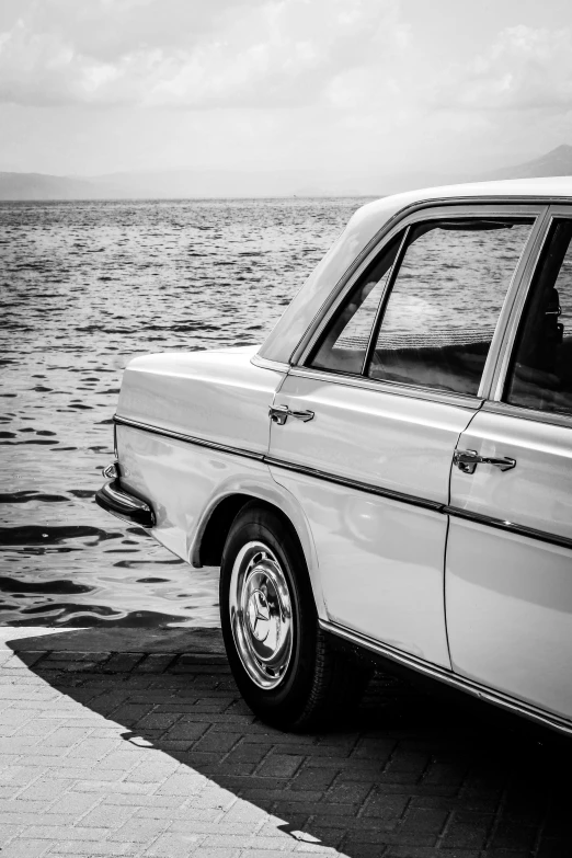 a small car parked by the water on a pier