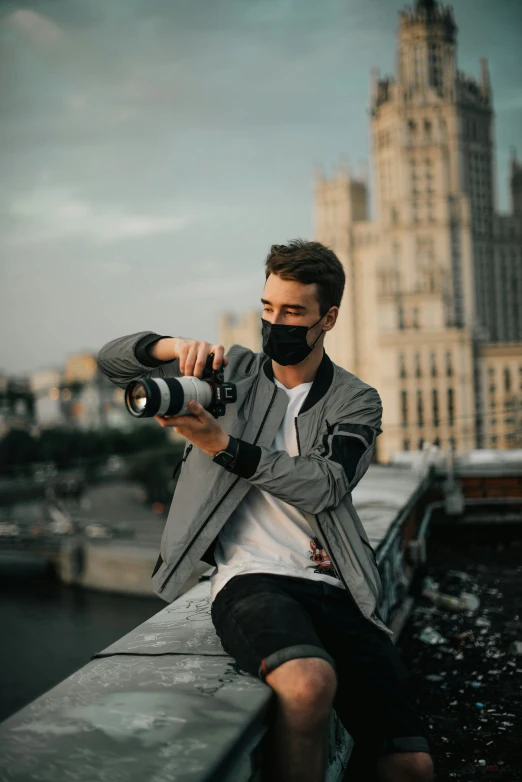 man in grey jacket and bandana taking pictures with his camera