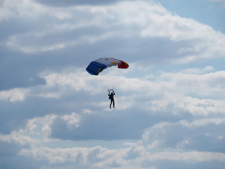 a person is parasailing in the air on a cloudy day