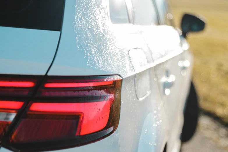 the tail lights of a white car with snow on it