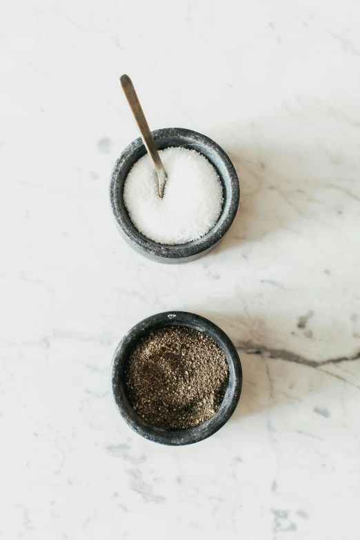 a couple bowls of white stuff on a marble table