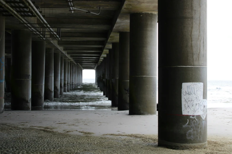 an empty street beneath a pier on the beach