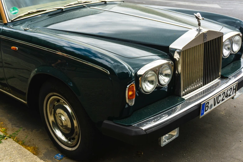 an old black rolls royce parked on the side of a street