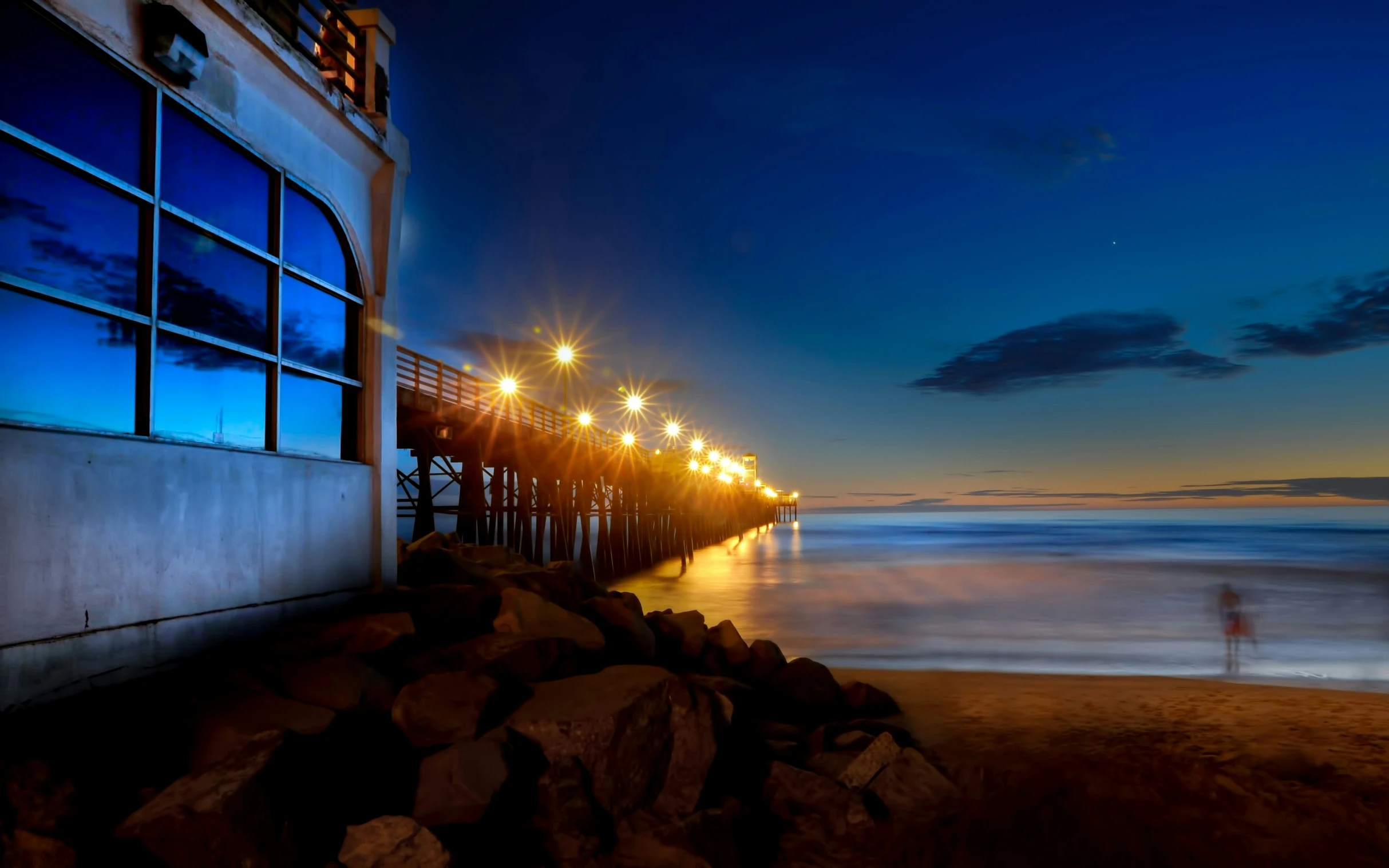 a pier lit up by light bulbs at night