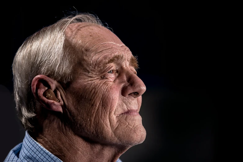 an older man with an earpiece on his head looking up