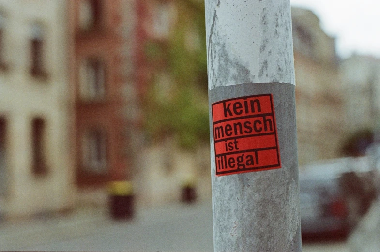 a close up of a pole with street signs and buildings in the background