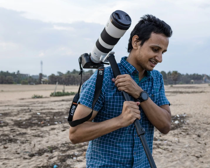 the man is carrying a telescope in his hand