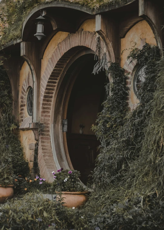 the entrance to an outdoor building with plants growing around