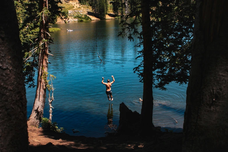 a man standing in water with two trees around