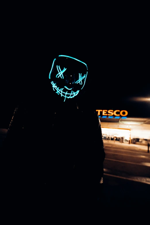 someone wearing a neon mask standing in the street