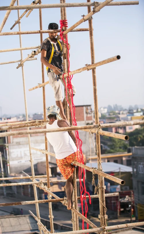 two men standing on scaffolding working on the roof