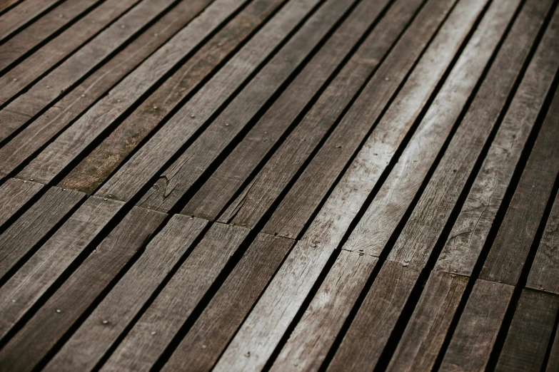 an outdoor wooden deck with a bench next to it