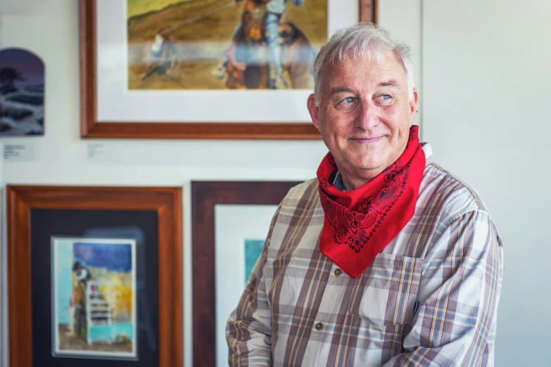 older man wearing scarf looking at camera in residential setting