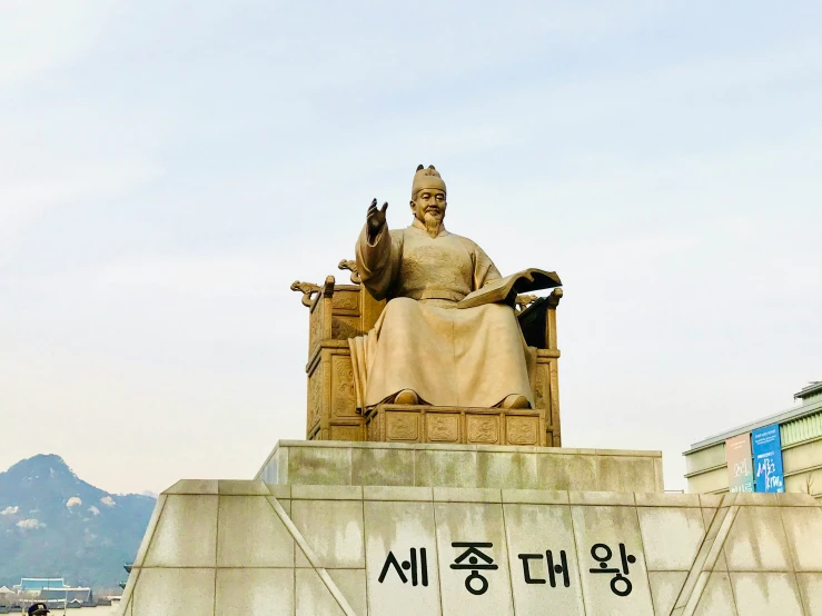 a statue of a seated person on top of a bench