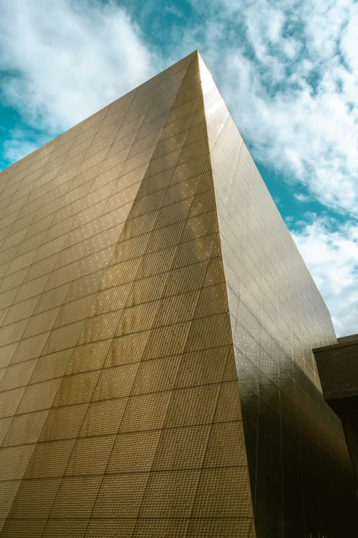 a tall brown building sitting under a blue sky