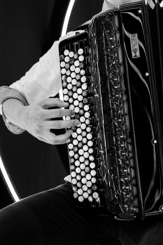 a person is playing an accordion in black and white