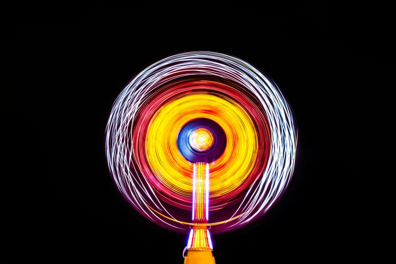 a spinning carousel wheel in the dark at night