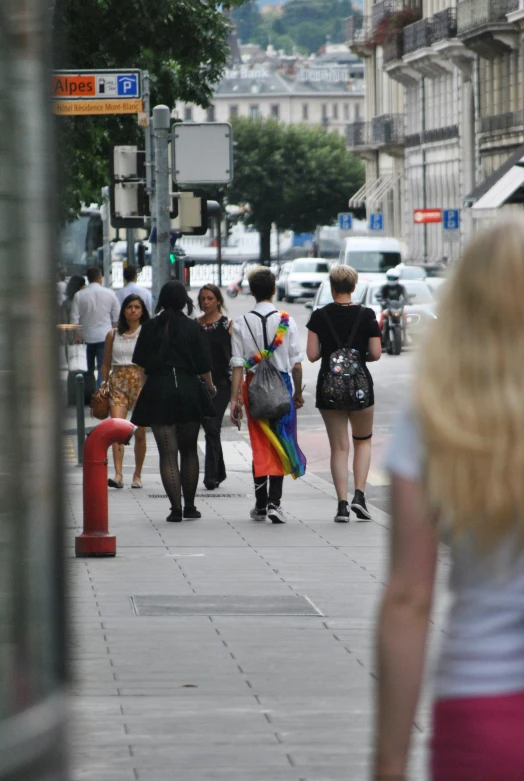 a group of people walking down a sidewalk