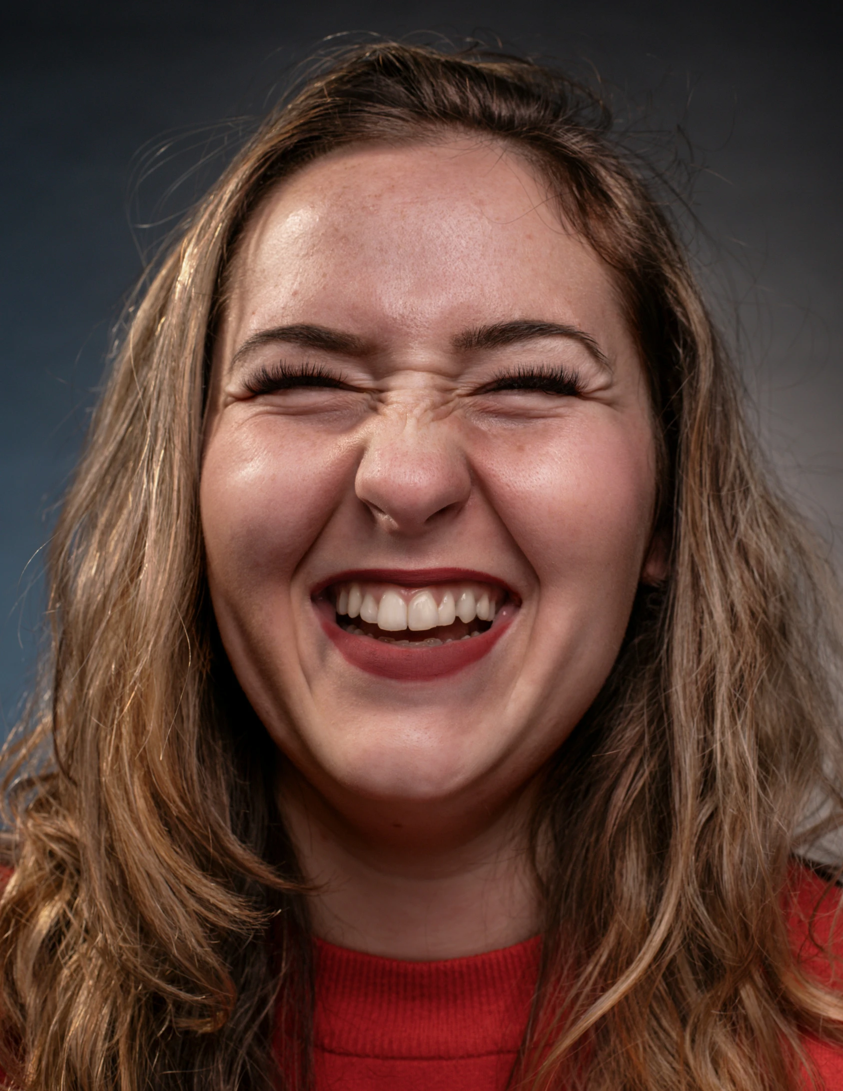 the woman smiles for the camera and has big white teeth