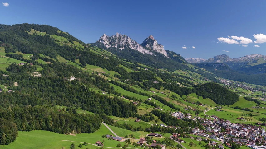 the mountains in a village with a green lawn