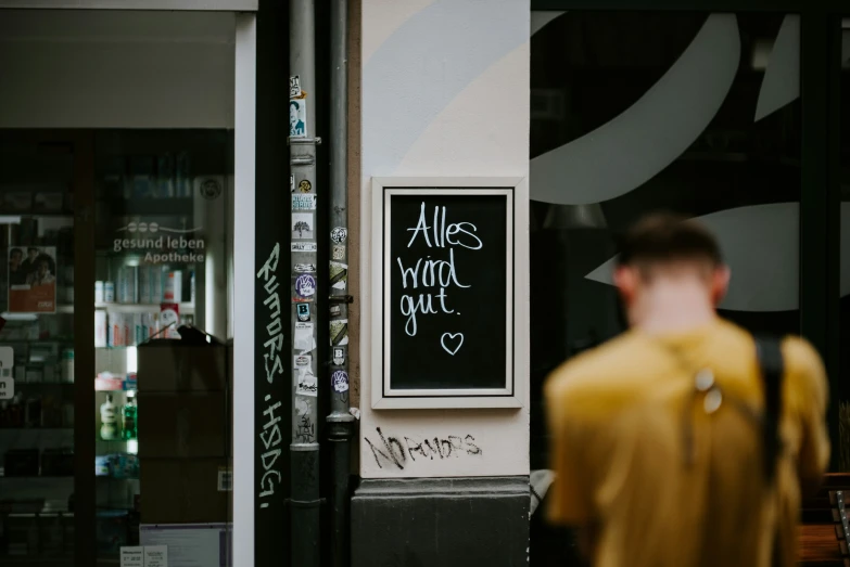 a person standing in front of a blackboard sign