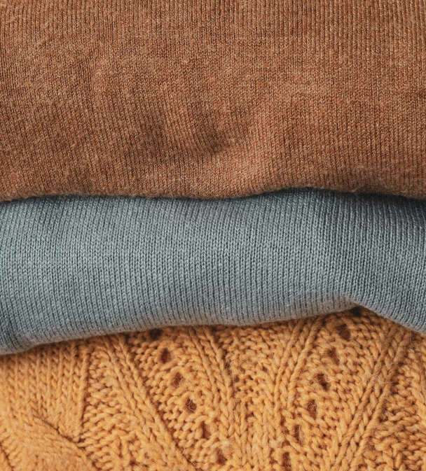 an assortment of different colors of wool, including camel, blue and brown