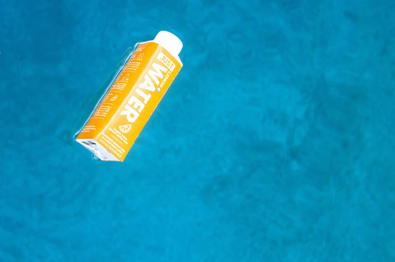 an orange and yellow tube is on a bright blue surface