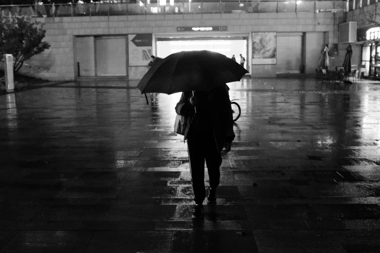 there is a woman holding an umbrella while walking on the street