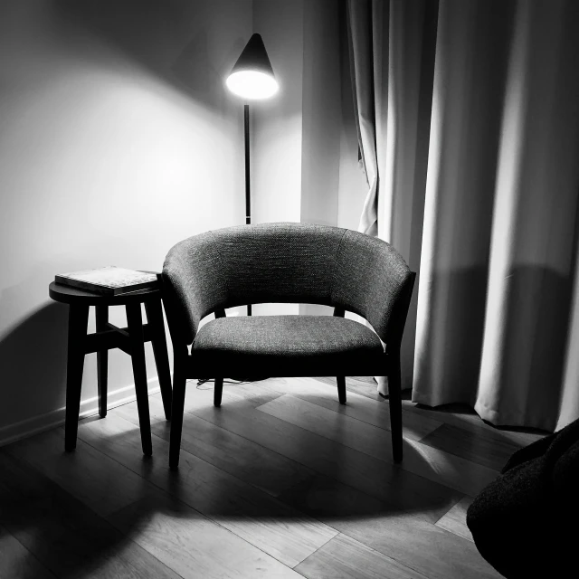 a chair and two stools in the corner with ds open