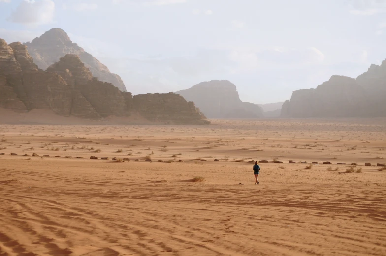 a man is walking in the middle of an arid area