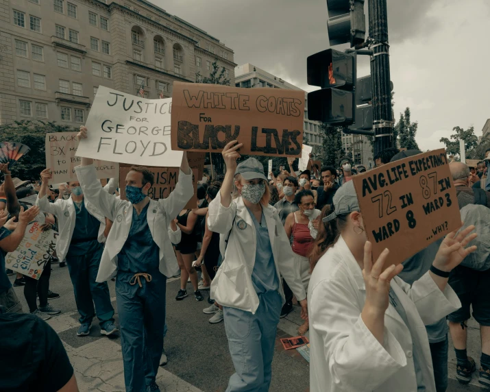 a group of people carrying signs and walking down the street