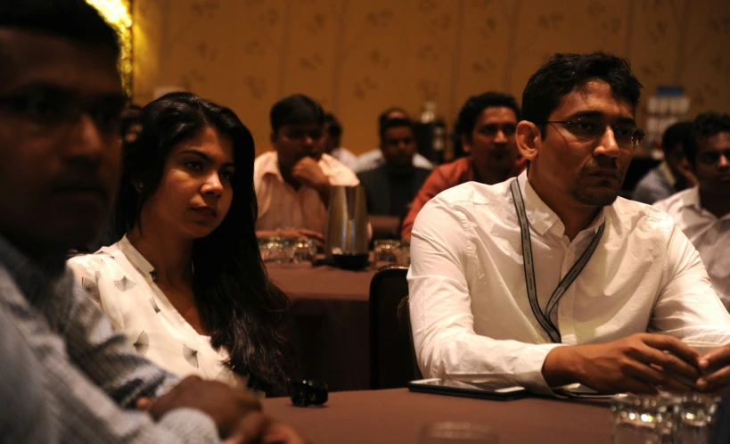 a crowd of people at a conference waiting for the next speaker