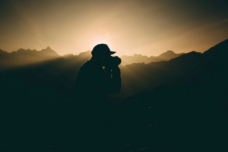 a person on top of a mountain under a cloudy sky