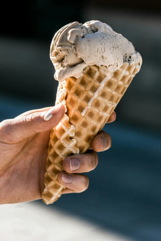 a person holds out their hand to eat ice cream