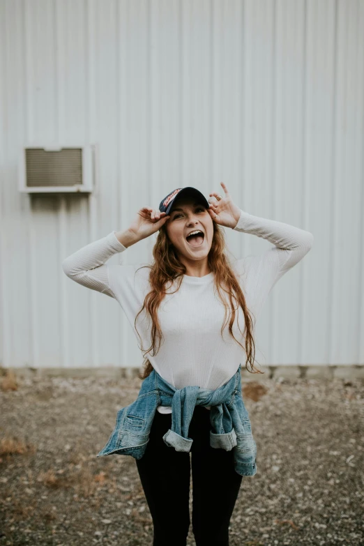  laughing while wearing white long sleeved shirt and denim hat