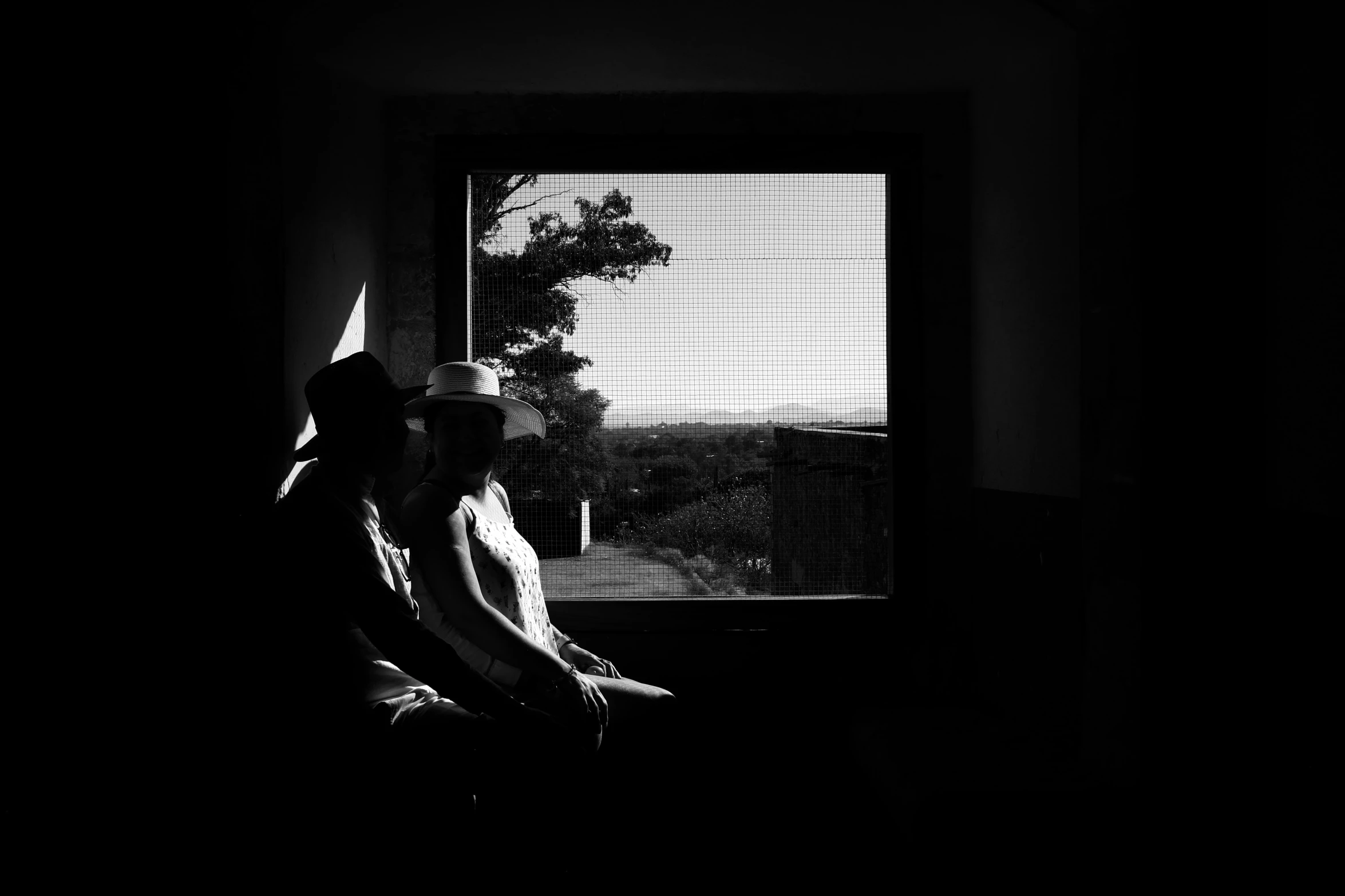 two girls are sitting together by the window