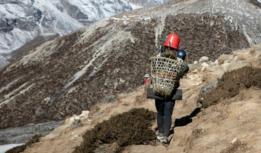 a person walks up a hill with a backpack