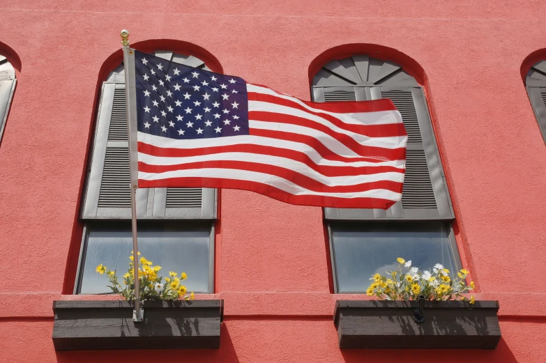 a red building has two american flags hanging off of windows