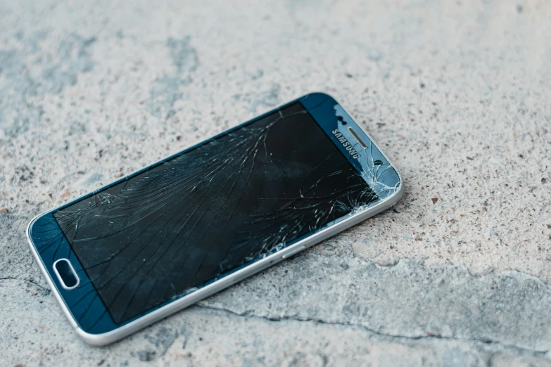 an open cellphone that is broken and lying on the ground