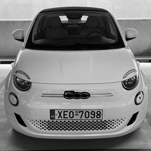 a white car with its hood up in black and white