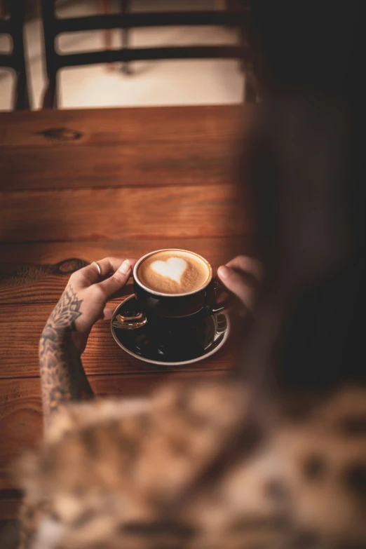 a man holding a cup of coffee and looking down at it