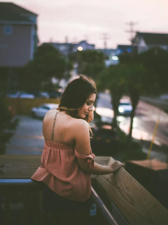 a woman with long brown hair looking out at the distance